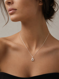 Necklace with a heart pendant worn by a model against a neutral background