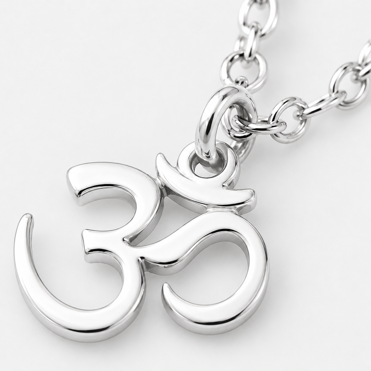 Silver Om symbol pendant on a chain against a white background