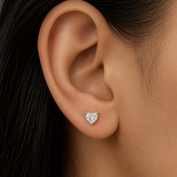 Heart-shaped diamond earring on a model's ear